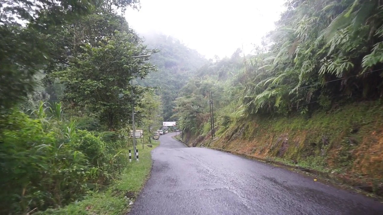 旅途中有自然风光的山峦和高大的绿树，白天的天气多云雾蒙蒙的雨后视频素材