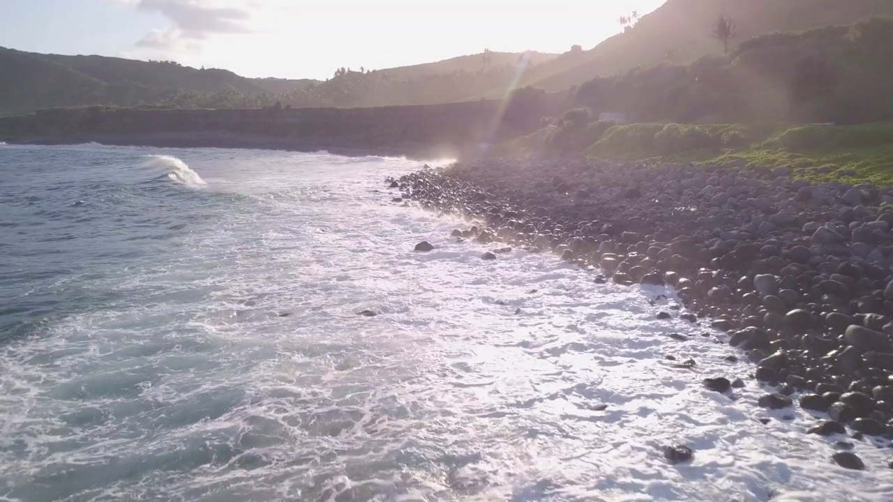 菲律宾巴丹斯岛的海岸线。在夕阳的余晖下，波浪冲刷着布满岩石的海岸视频素材