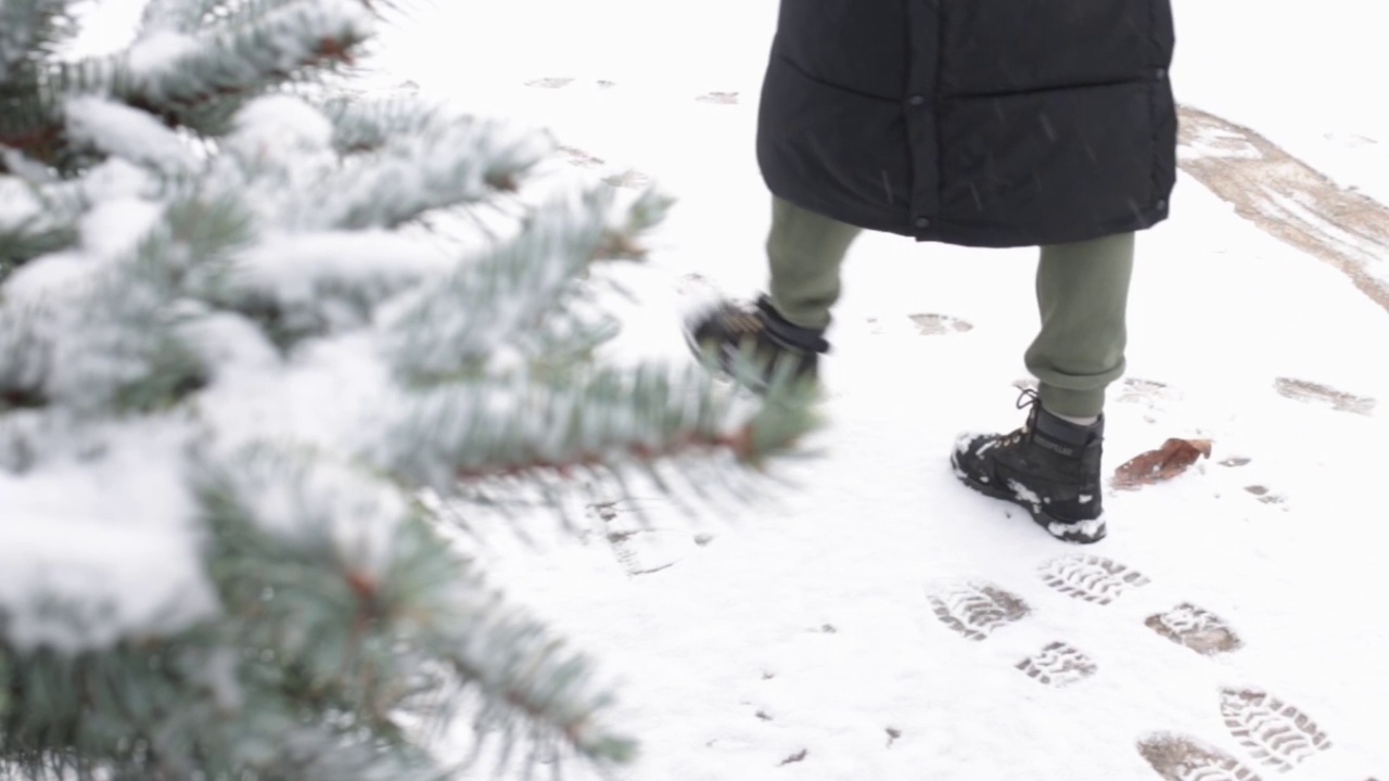 穿着黑色冬靴的女孩走在雪地里视频素材