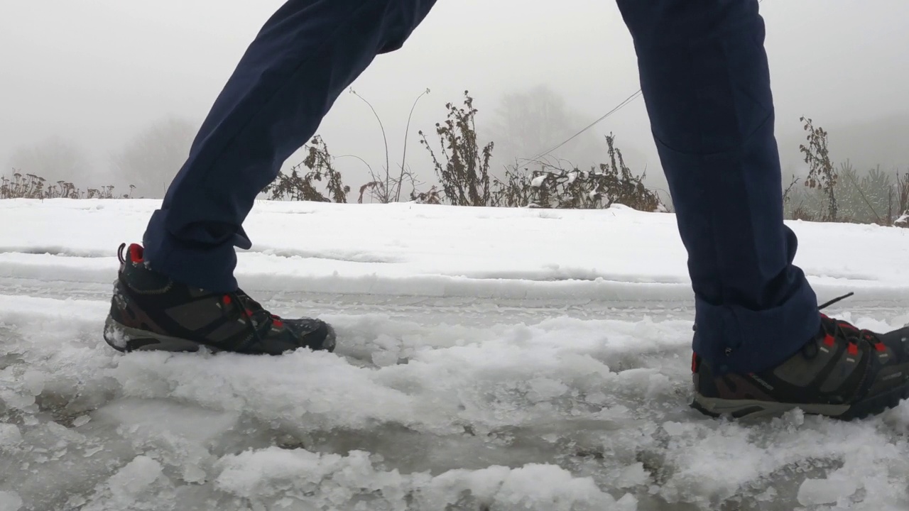 低视野的徒步者，脚，腿行走，登山在一个雪天雾天视频素材