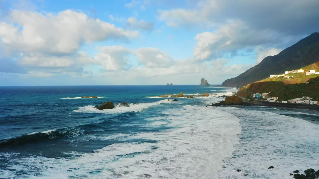 波涛在加那利岛的岩岸峭壁上飞溅起泡沫。空中高山自然景观宁静的背景。暴风雨天气下在水面上低空飞行。视频素材