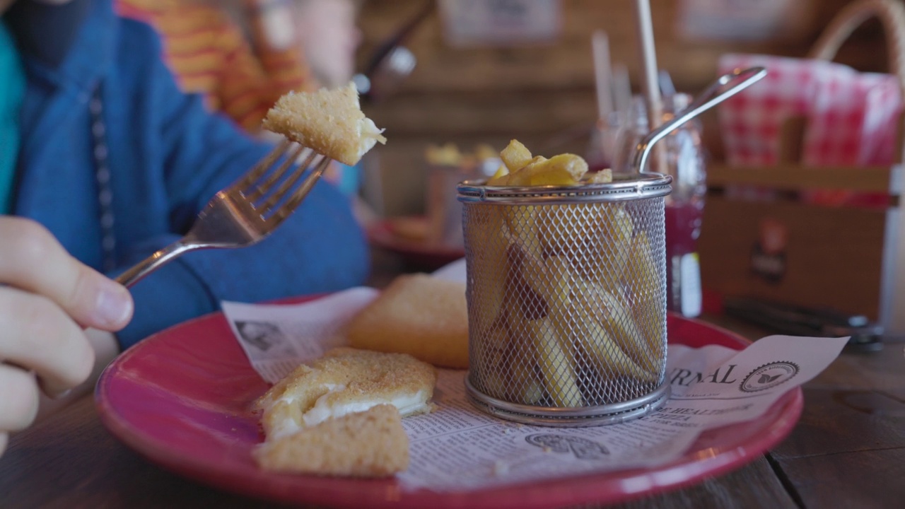 Closeup of teenager having traditional Slovak "vyprážaný syr" or fried cheese视频素材