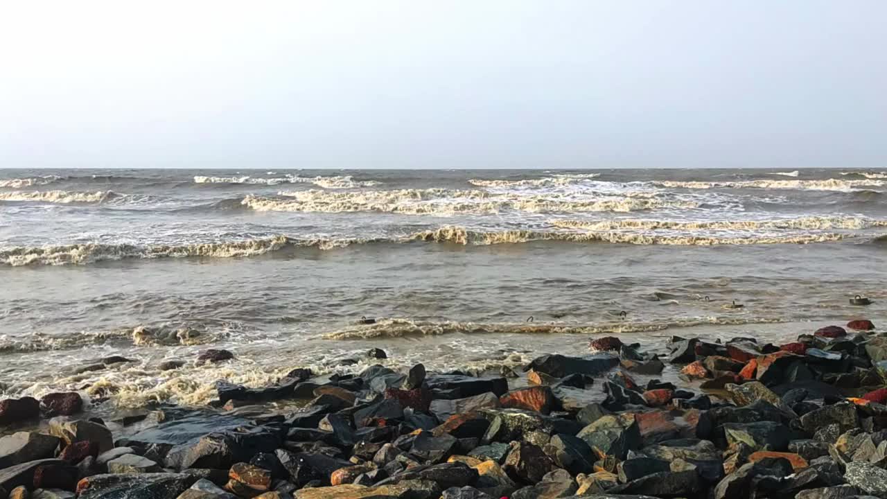 在清澈的天空背景下，令人叹为观止的海浪撞向海岸上的岩石视频素材