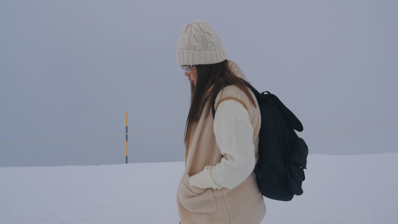 走在雪地上的年轻女子视频素材