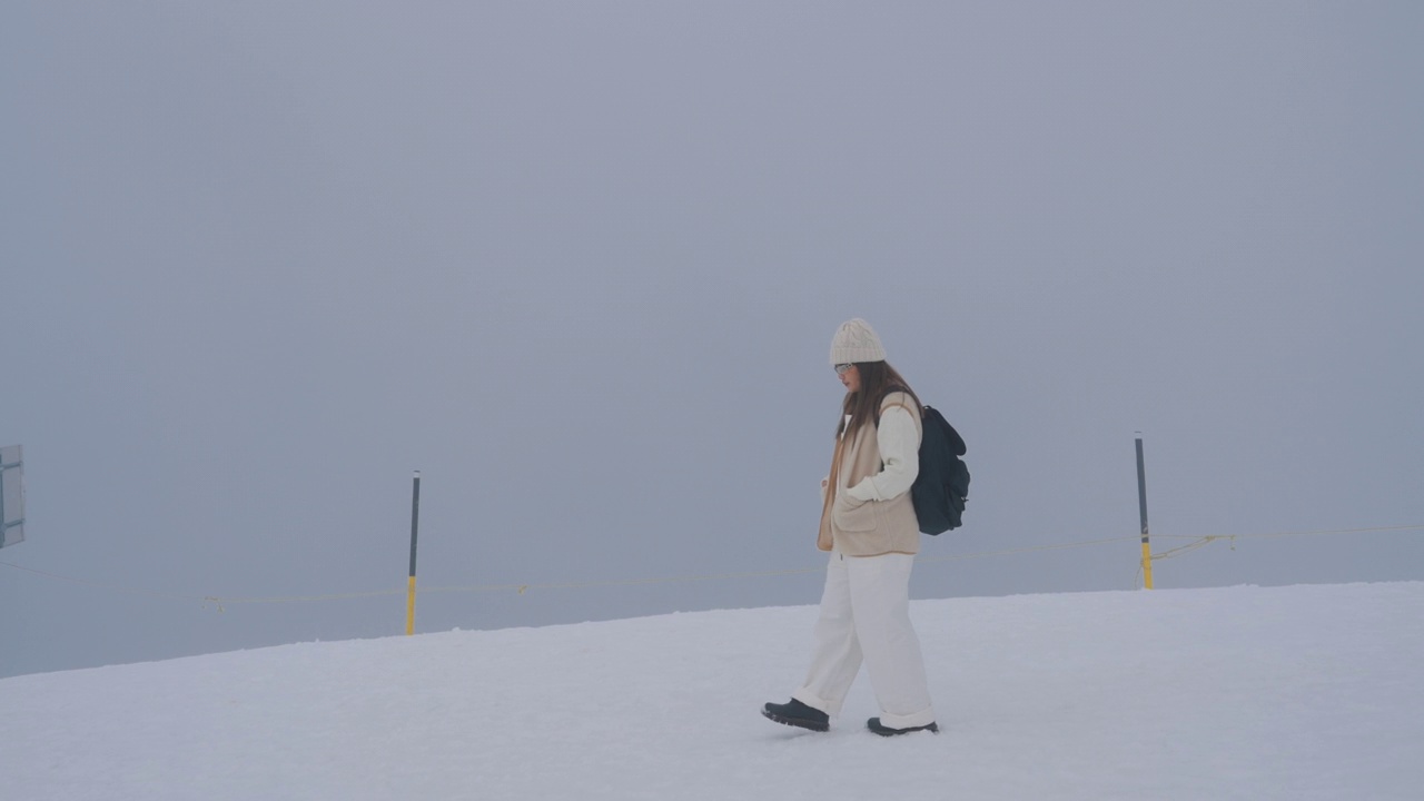 走在雪地上的年轻女子视频素材