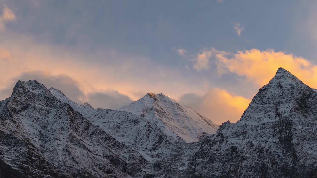 在印度喜马偕尔邦的拉豪尔，在白雪覆盖的喜马拉雅山脉上空移动的云的4K时间间隔。在冬天的山上，傍晚日落时，天空会消失。自然与环境视频素材