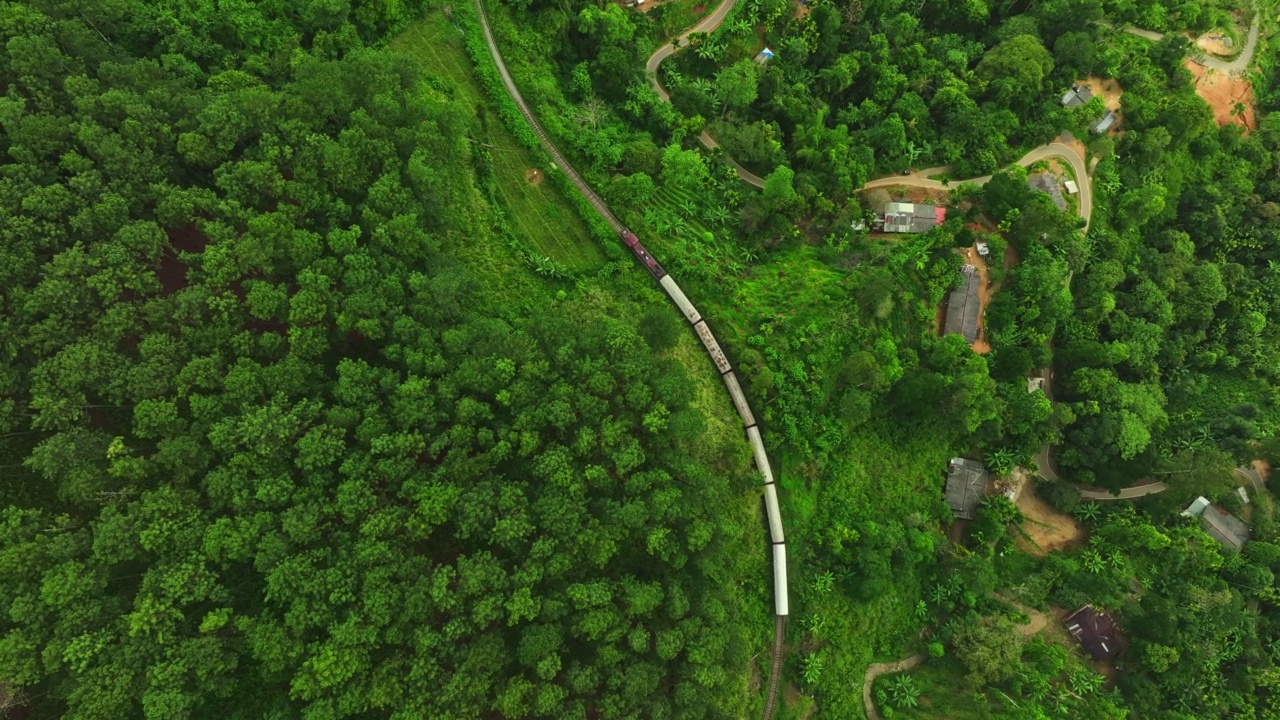 航拍的旅客列车在铁路上移动，通过森林地区在斯里兰卡视频素材