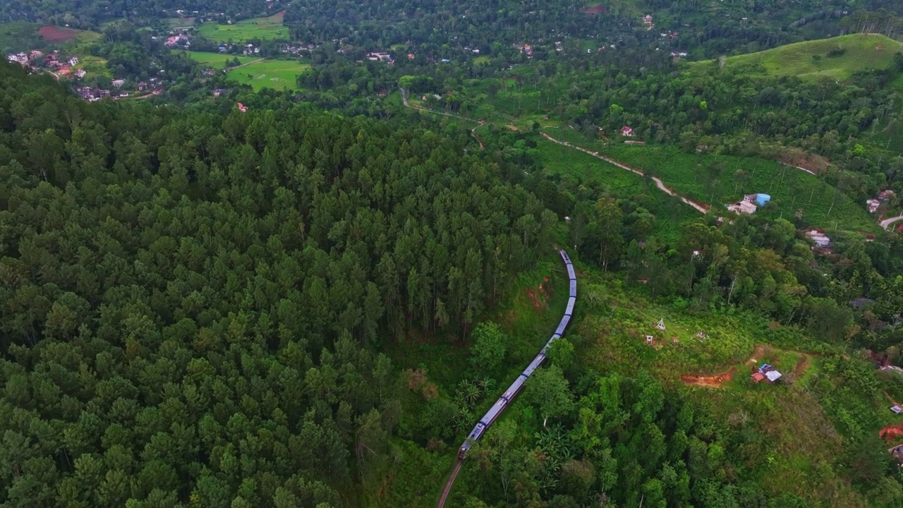 航拍的旅客列车在铁路上移动，通过森林地区在斯里兰卡视频素材