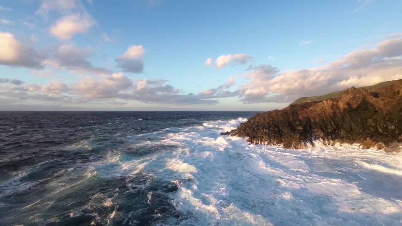 空中飞行距离很近，泡沫的浪花浪花冲毁了岩石海岸，被日落冲毁视频素材