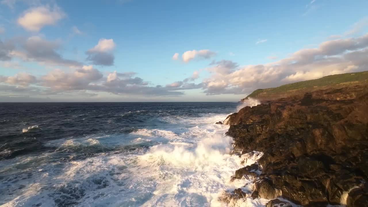 空中飞行距离很近，泡沫的浪花浪花冲毁了岩石海岸，被日落冲毁视频素材