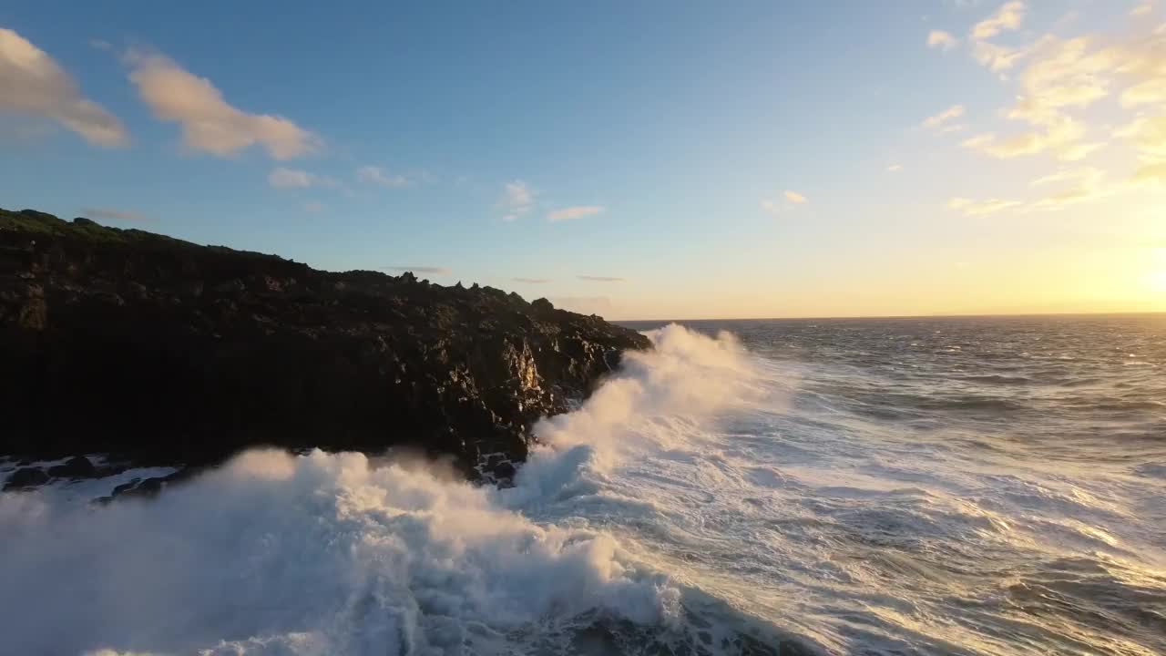 空中飞行距离很近，泡沫的浪花浪花冲毁了岩石海岸，被日落冲毁视频素材