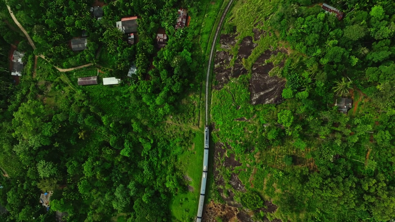 航拍的旅客列车在铁路上移动，通过森林地区在斯里兰卡视频素材