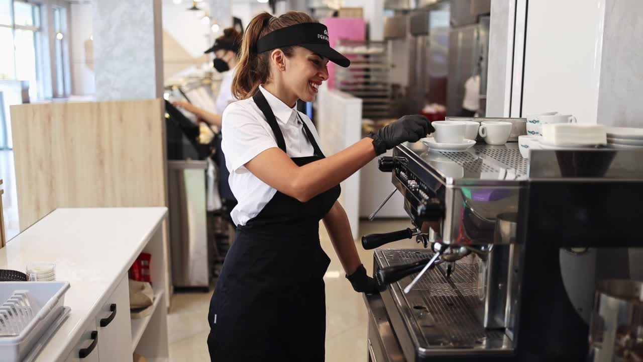 漂亮的年轻女子在咖啡机前工作视频素材