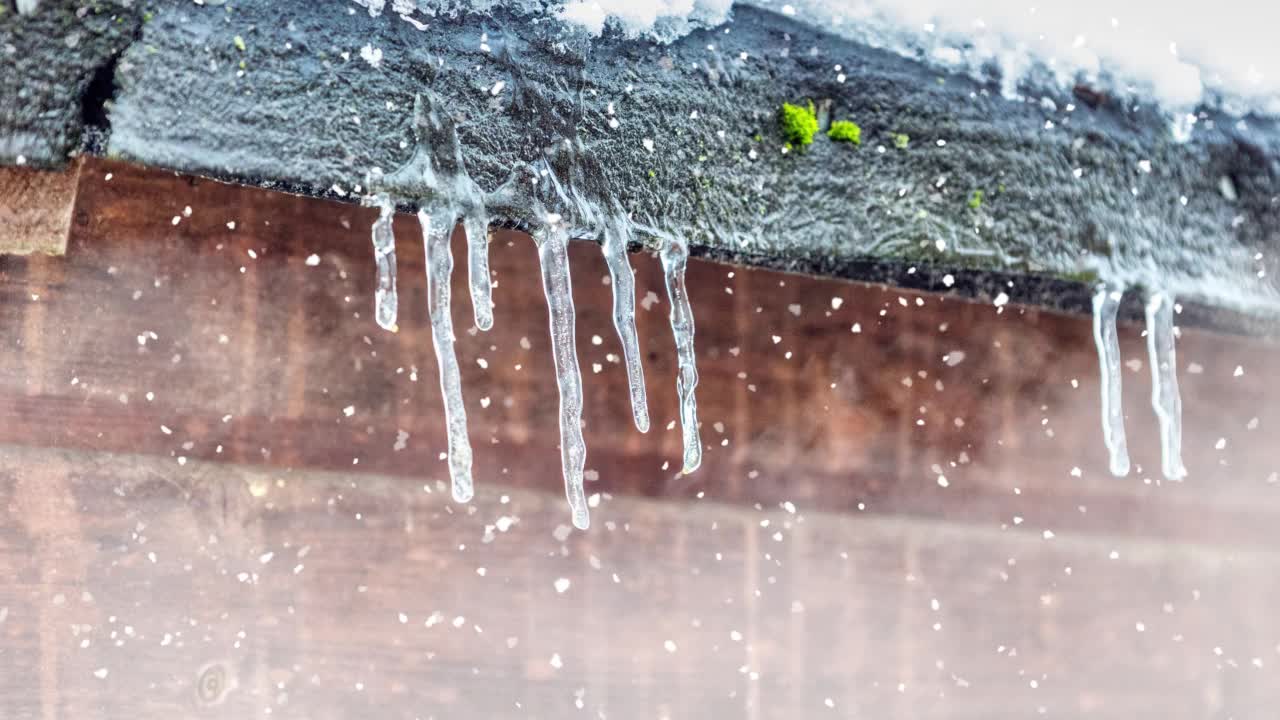 雪中屋顶上悬挂的冰柱视频素材