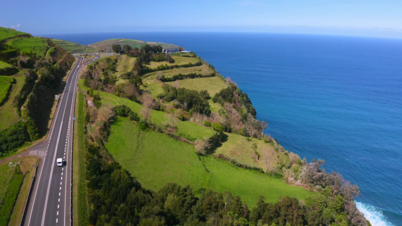 在葡萄牙的Ilha de Sao Miguel，在美丽的山丘和绿色的草地之间的道路景观视频素材