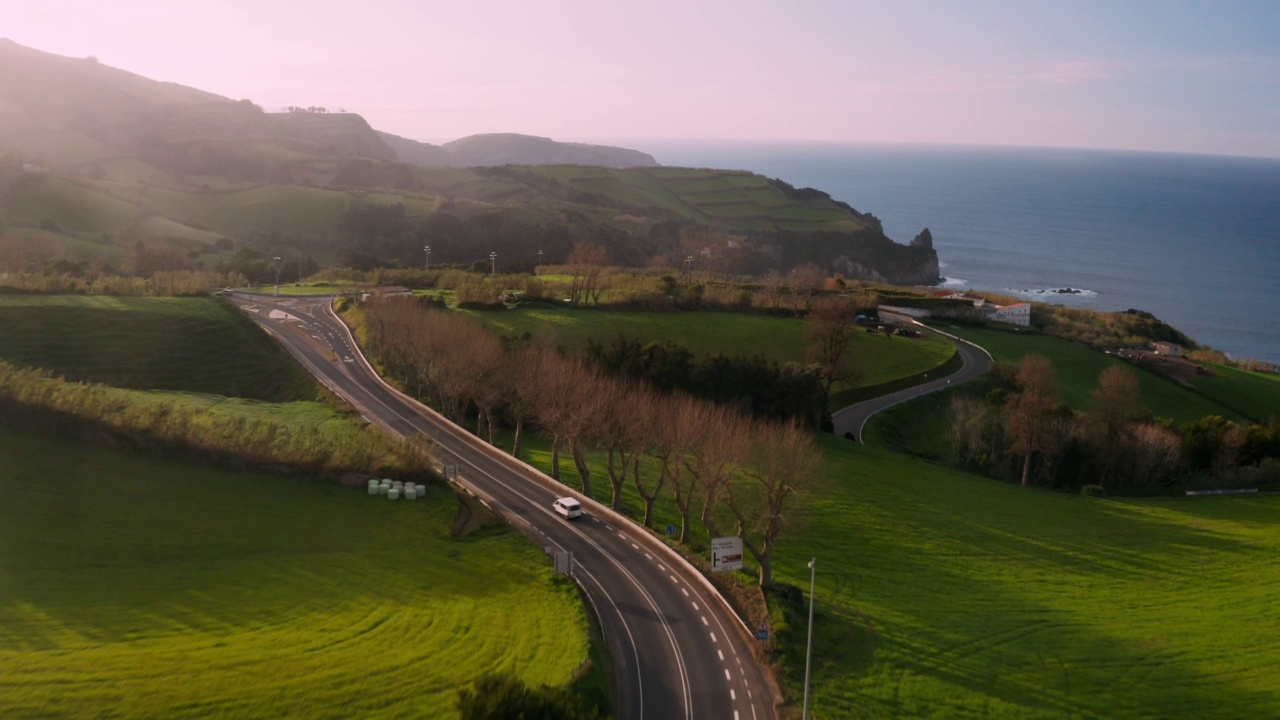 在葡萄牙的Ilha de Sao Miguel，在美丽的山丘和绿色的草地之间的道路景观视频素材