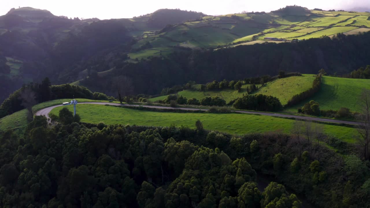 在葡萄牙的Ilha de Sao Miguel，在美丽的山丘和绿色的草地之间的道路景观视频素材