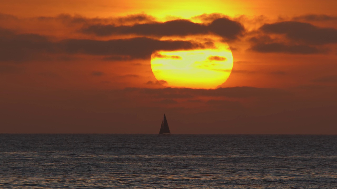 在葡萄牙海岸的大西洋上，美丽的夕阳和一艘帆船。视频素材