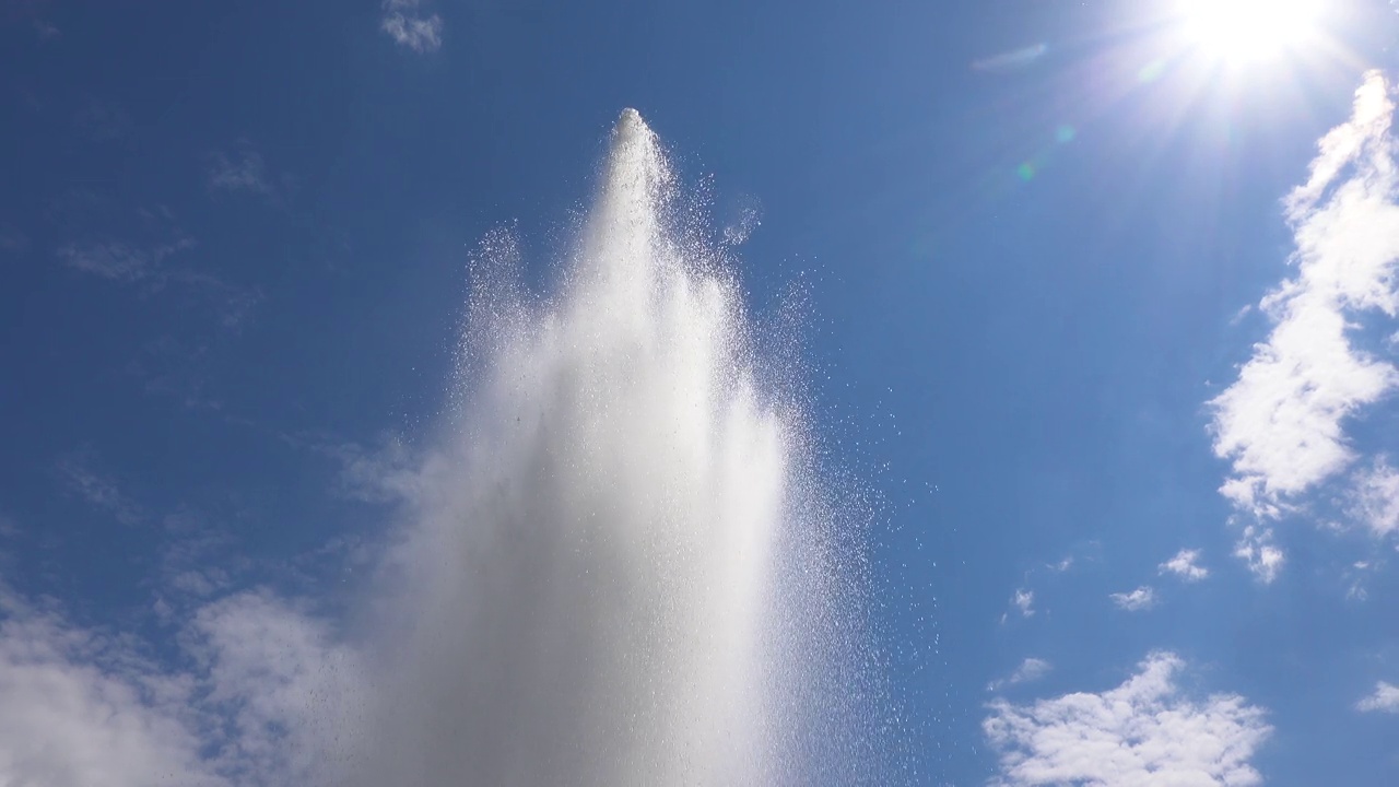 在阳光明媚的日子里，喷涌的喷泉。水在空气中的爆炸运动视频素材