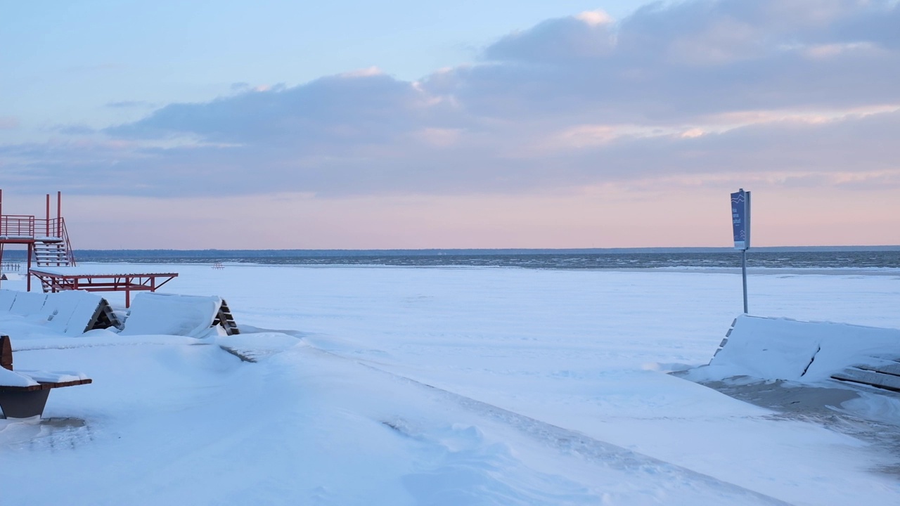 在海滩上日落的时候，海滩上的雪从风中蔓延开来视频素材