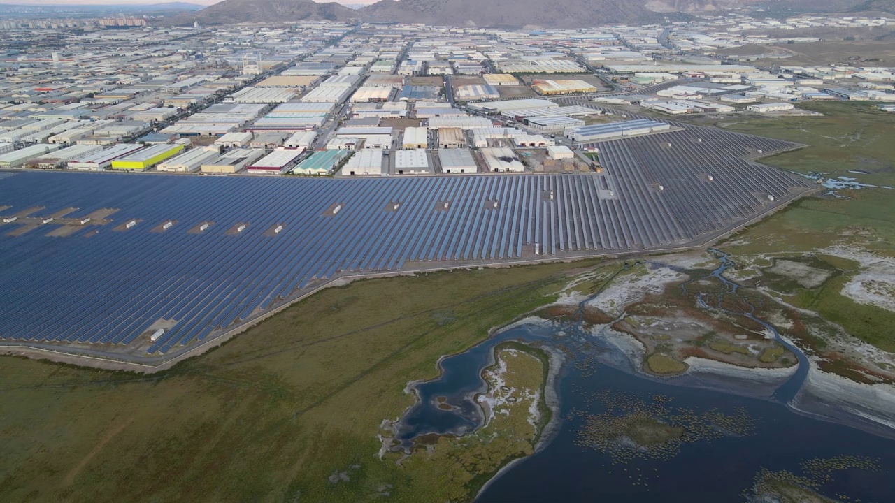 工业区旁边的太阳能发电站和湿地的俯视图。视频素材