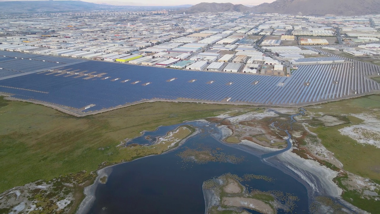 工业区旁边的太阳能发电站和湿地的俯视图。视频素材