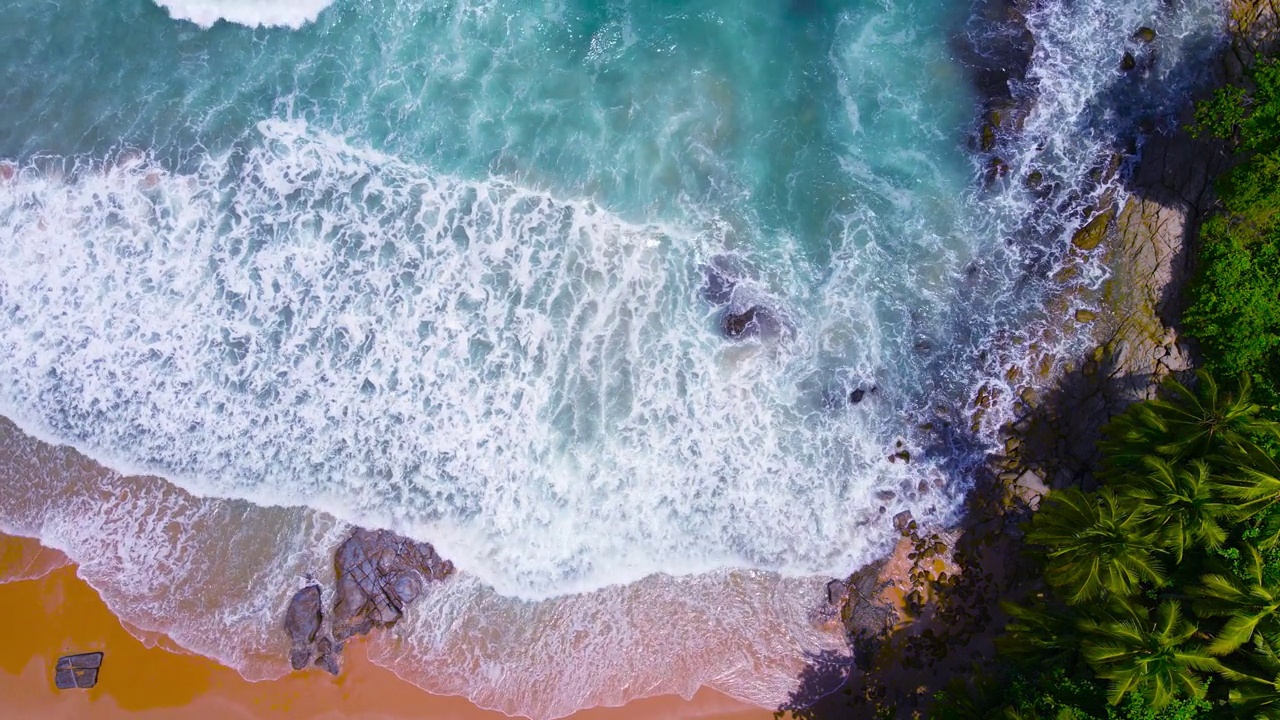 航拍视频美丽的特写拍摄的海滩和海水在海浪上的沙滩在日落时间(俯视图)自然和旅游概念视频。视频素材