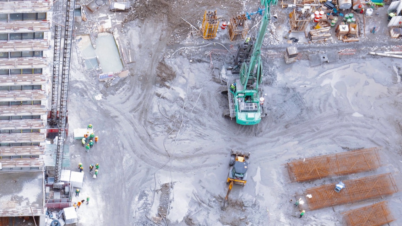 高架视图时间推移与建筑工地面积。发展多层住宅大楼。挖掘机等机械设备配合工时延时视频素材