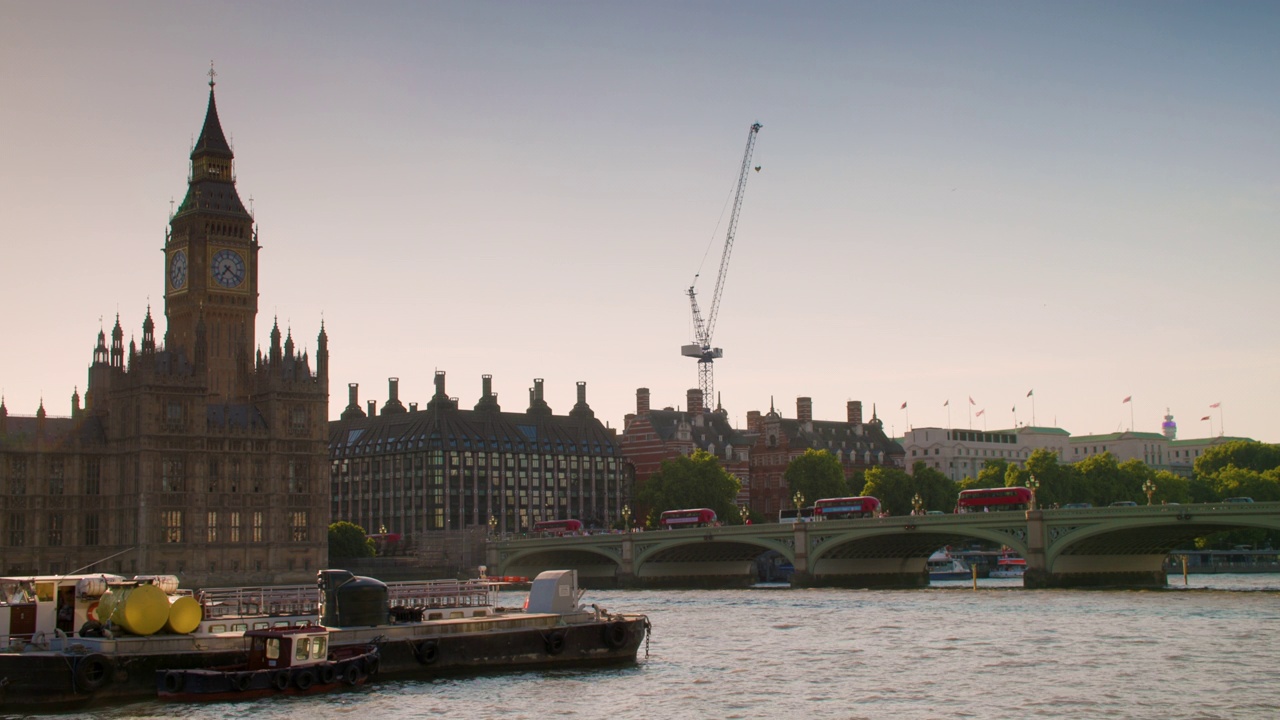 英国伦敦，人们、游客和红色巴士穿过泰晤士河上的威斯敏斯特大桥，经过议会大厦视频素材