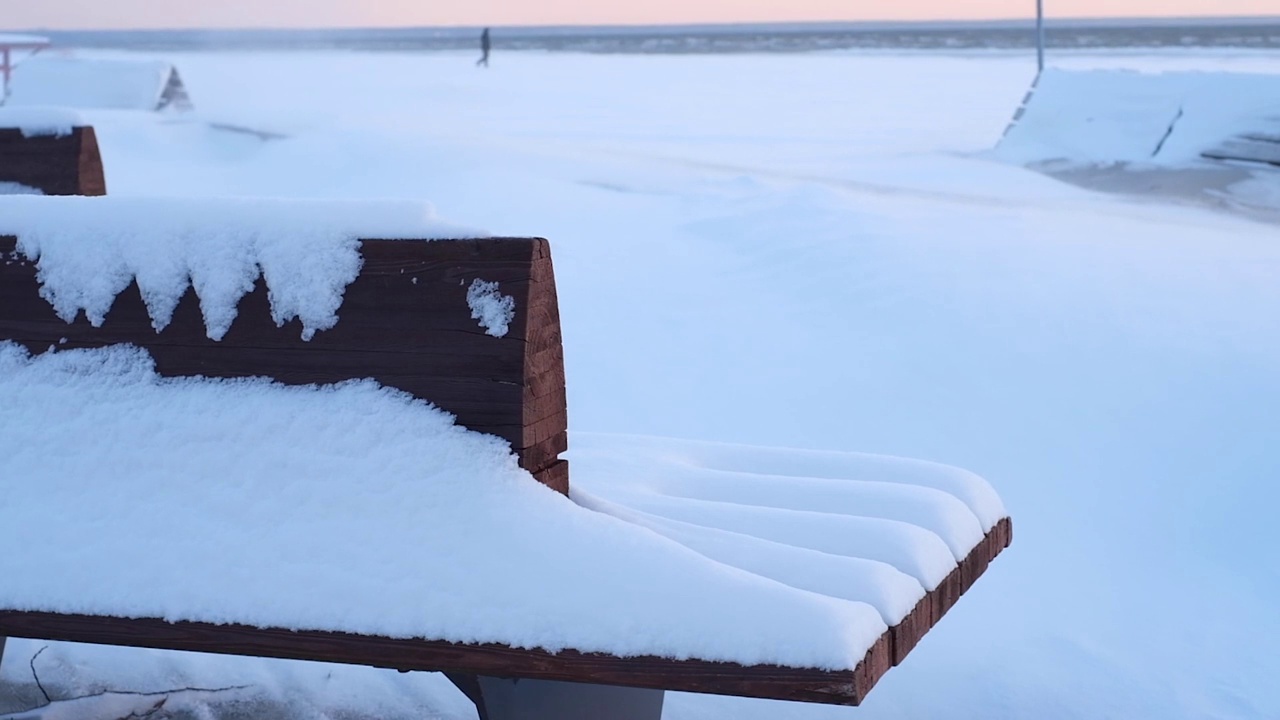 在海滩上日落的时候，海滩上的雪从风中蔓延开来视频素材