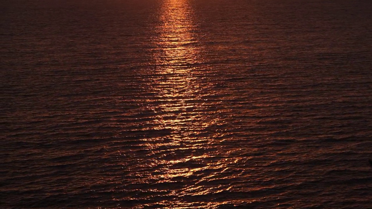 日落时平静的海面。日落时金黄色的平静海水。海水背景视频素材