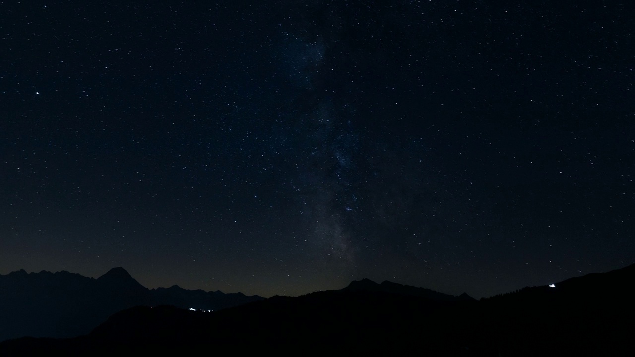 一个星夜的延时镜头，流动的云映衬着山的轮廓视频素材