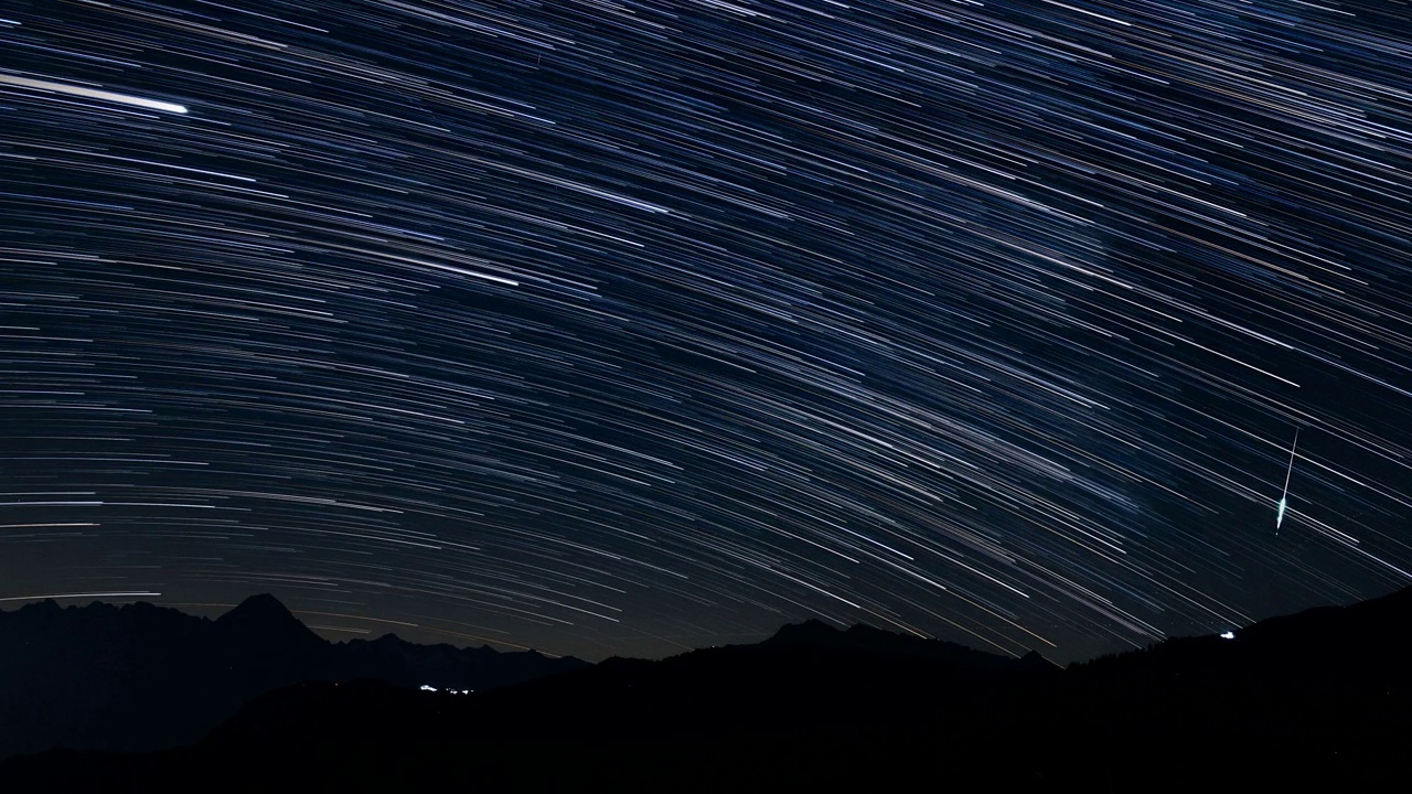 一个星夜的延时镜头，流动的云映衬着山的轮廓视频素材