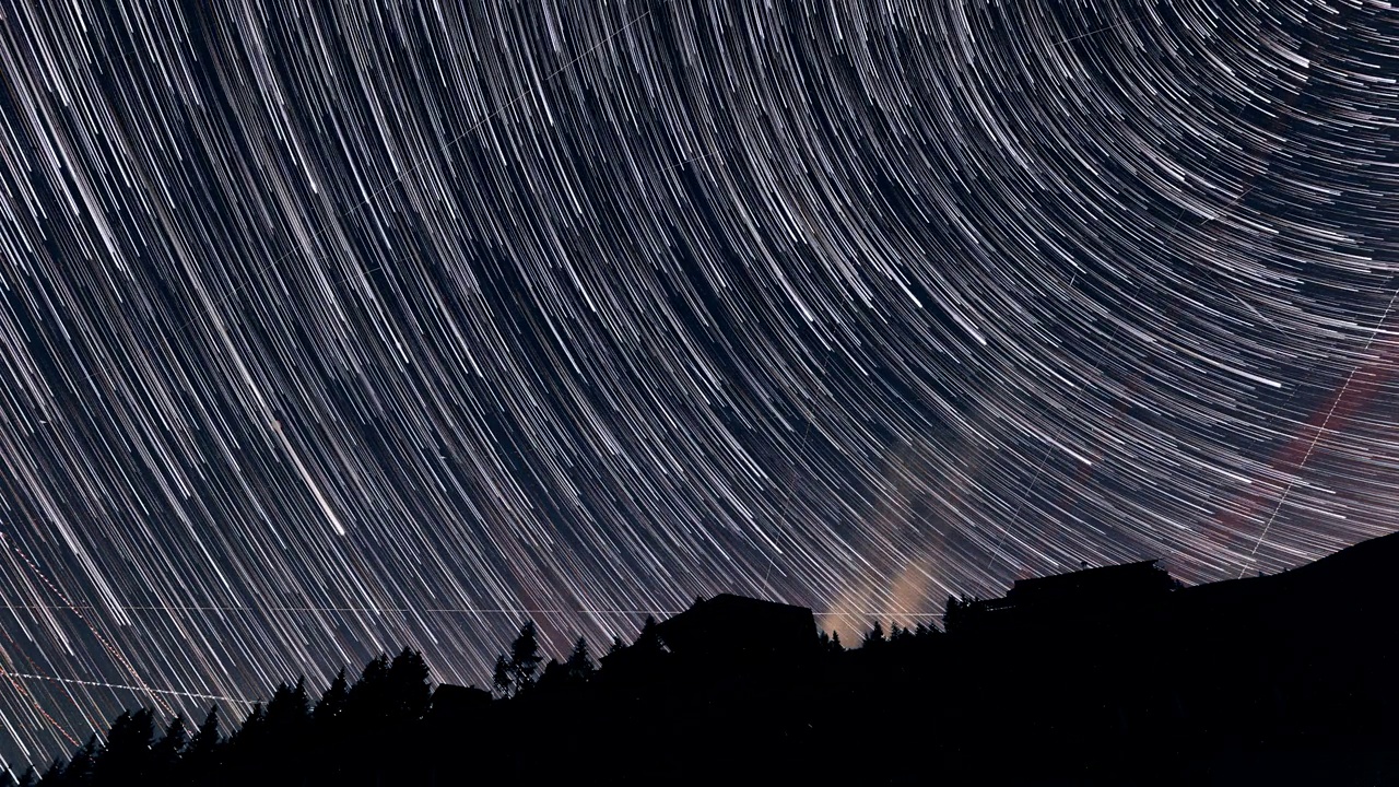 一个星夜的延时镜头，流动的云映衬着山的轮廓视频素材