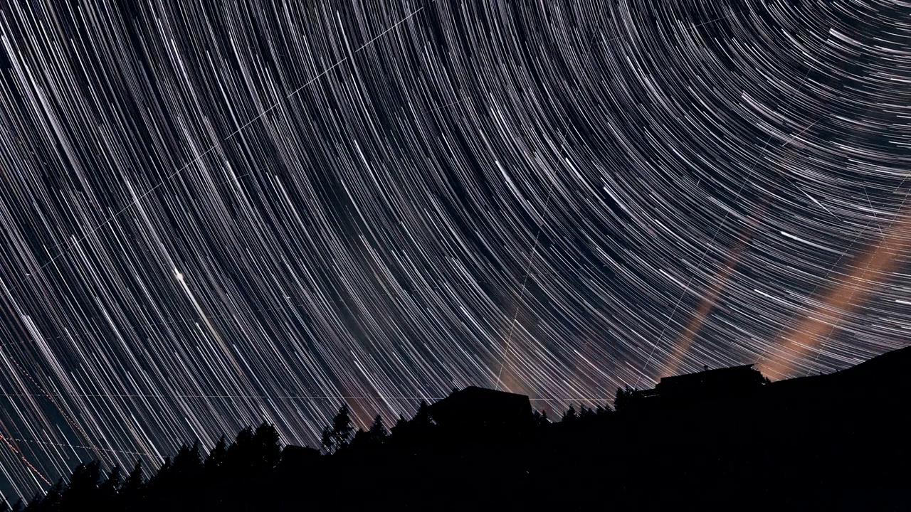 一个星夜的延时镜头，流动的云映衬着山的轮廓视频素材