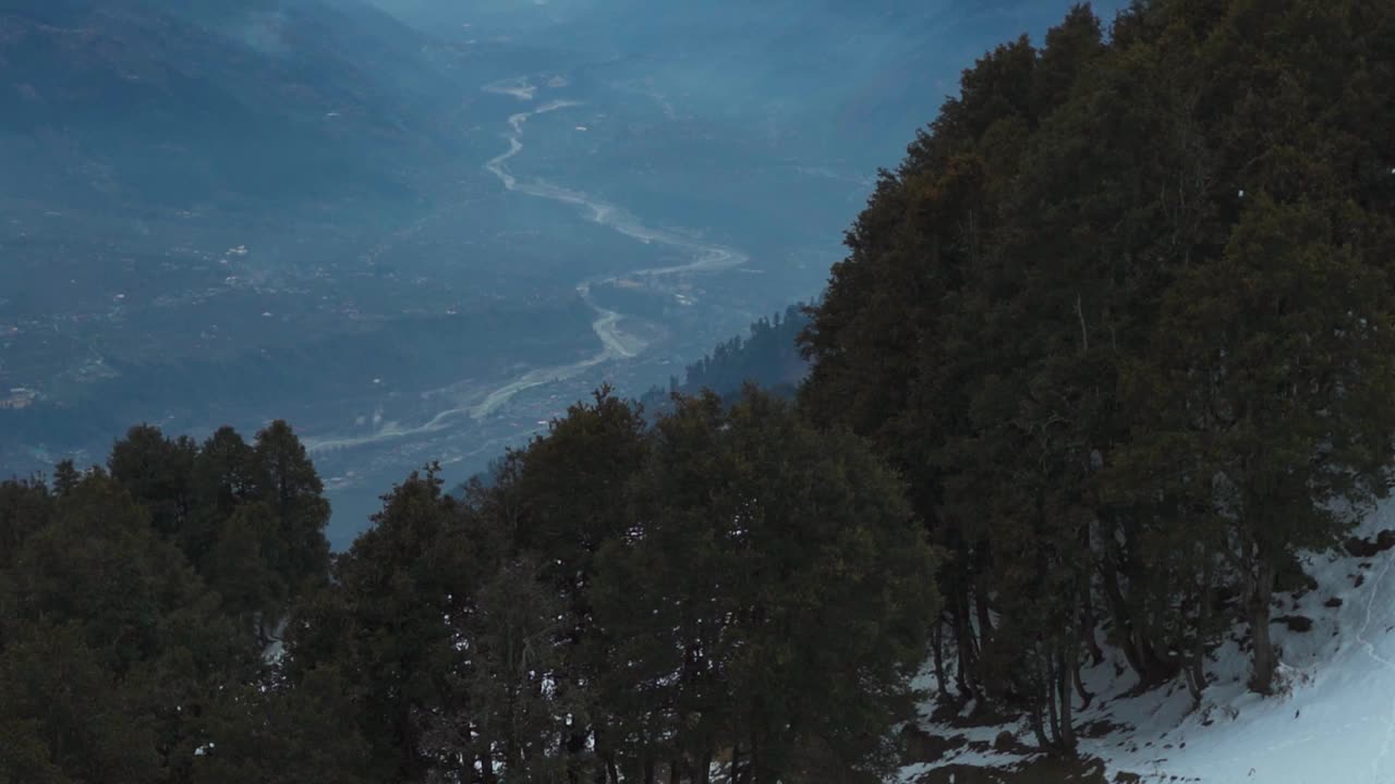 在印度喜马偕尔邦马纳利的Rani Sui湖徒步旅行期间，从Mahili茅草上看到的河流在库鲁山谷的山脉之间流动。从山上看河。视频素材