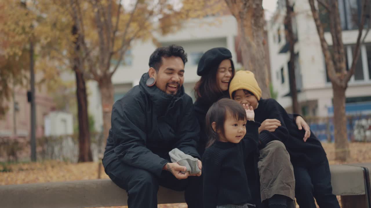 幸福的一家人在秋天的公园里玩耍，谈笑风生。视频素材