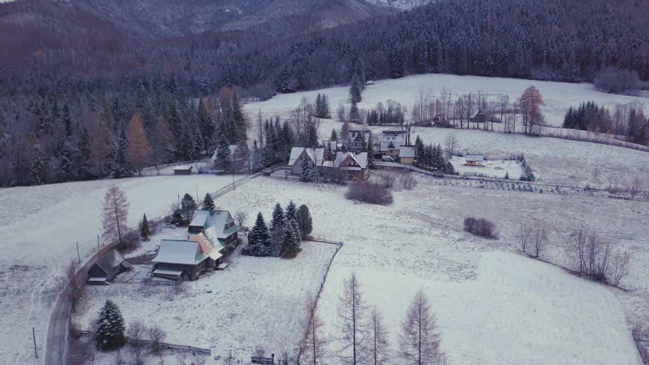 在波兰扎科帕内，无人机拍摄的被雪覆盖的房屋和山景视频素材