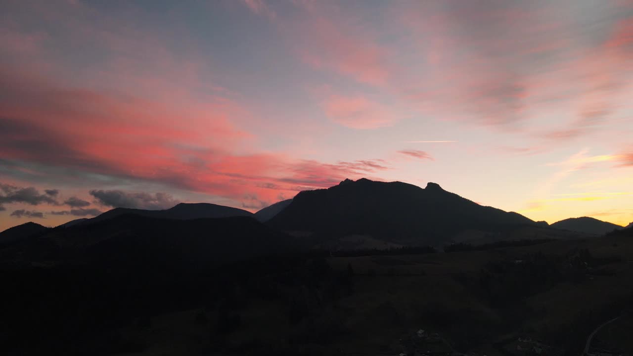 在五彩缤纷的夕阳下，风景如画的山脉和草地视频素材