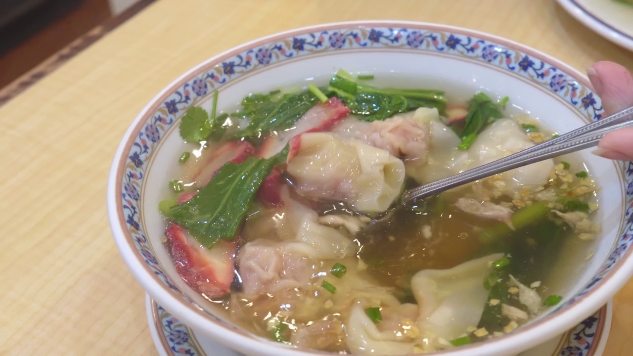 用勺子在白碗里吃馄饨叉烧汤。小麦面团水饺子馅虾和蔬菜。白碗虾饺汤——亚洲风味视频素材