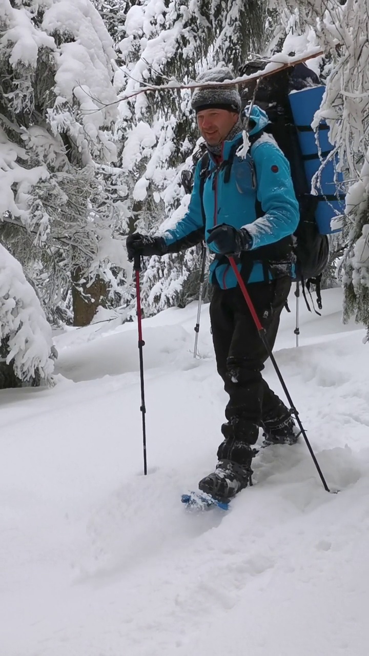 三个背着背包和雪鞋的男人在冬天徒步旅行。视频素材