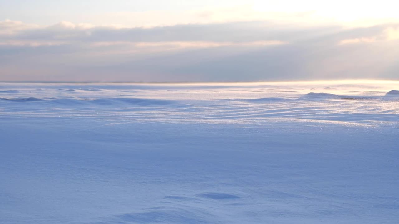 在海滩上日落的时候，海滩上的雪从风中蔓延开来视频素材