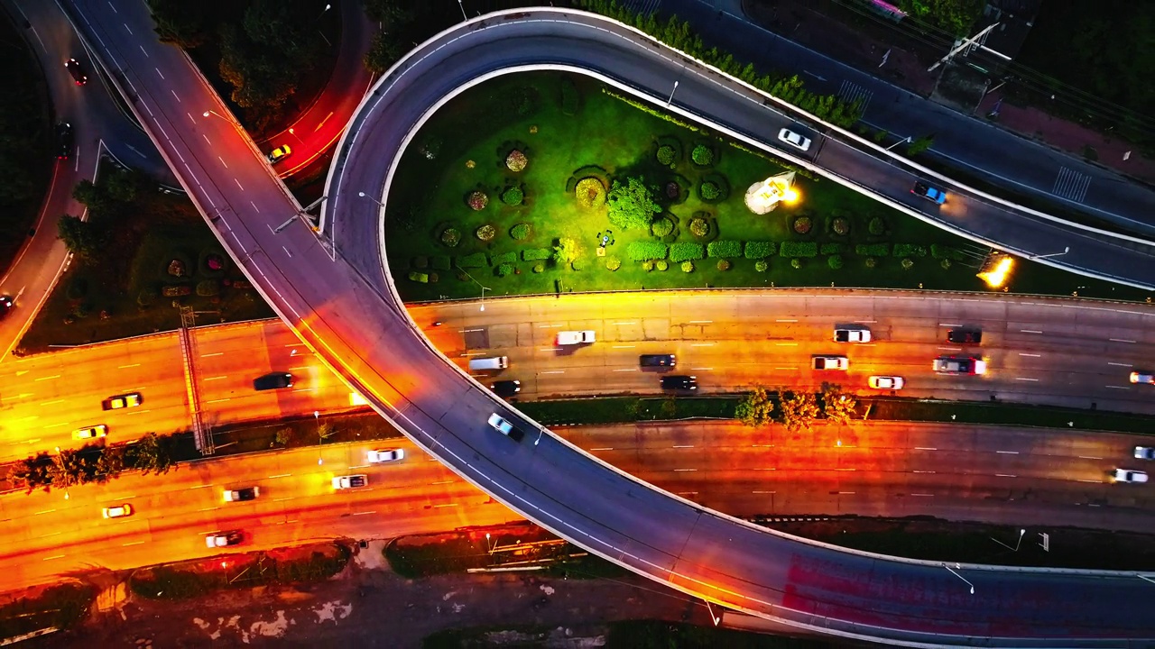 夜间道路交叉路口的航拍，高速公路交汇处的交通。夜间城市街道鸟瞰图，汽车在那空佛统行驶视频下载