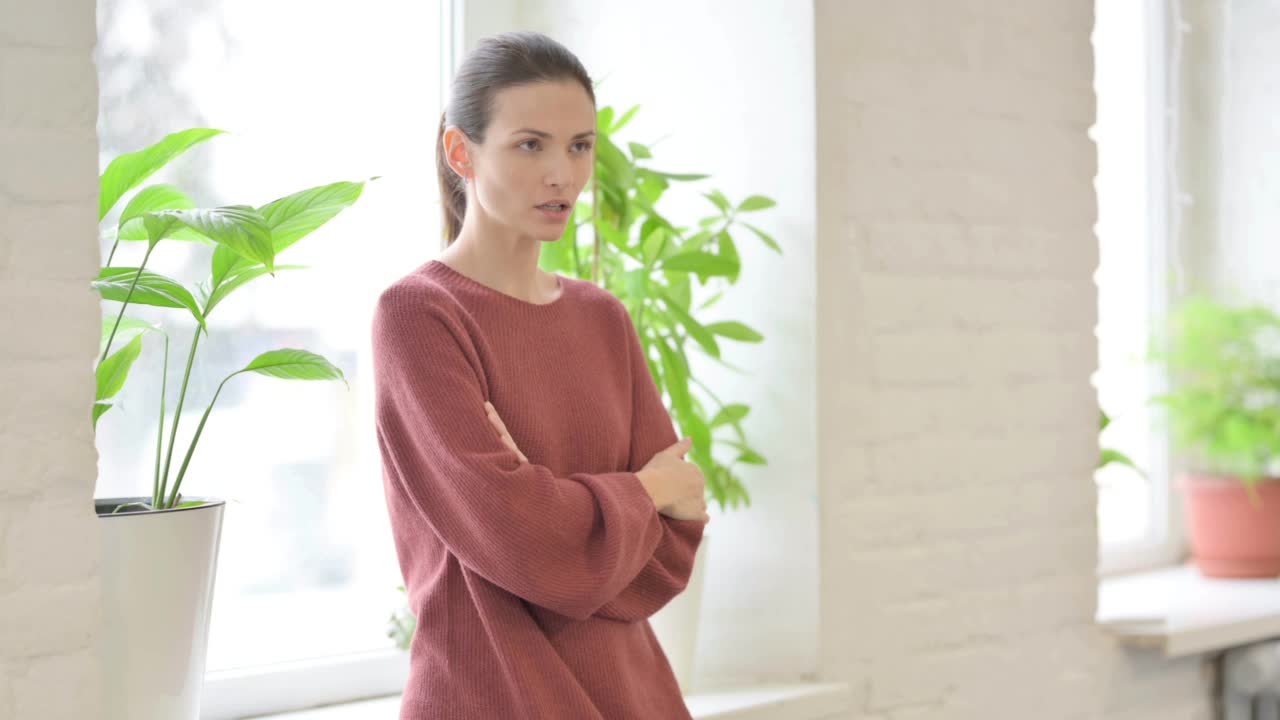 美丽的女人站在窗边微笑着看着镜头视频素材