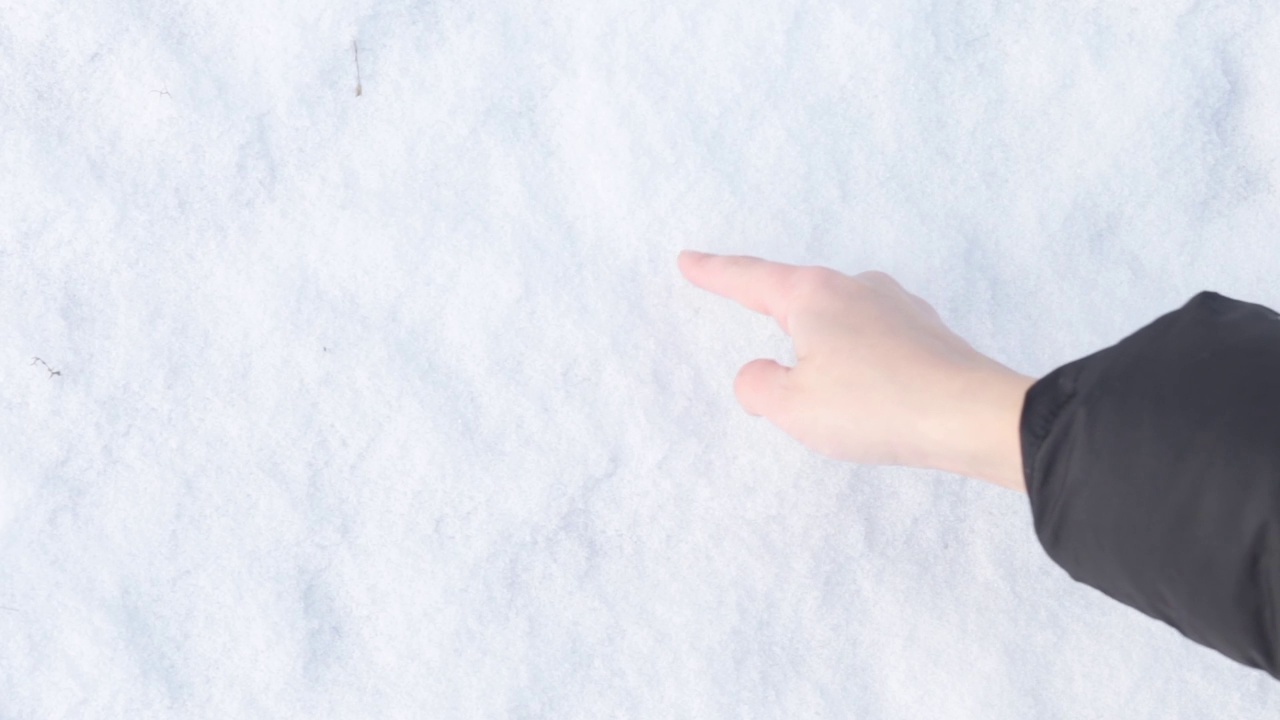 一个女人的手在雪地上画了一颗心。情人节的概念，浪漫和爱情的冬天视频素材