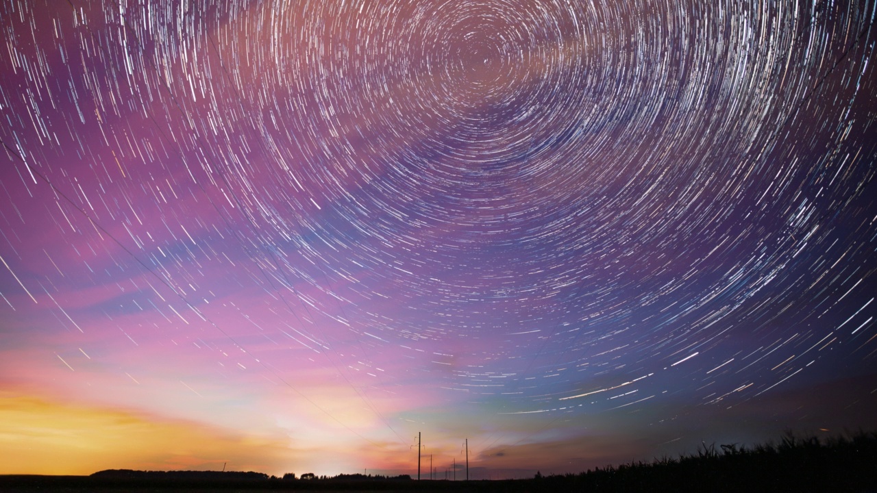 4k时间推移夜空星空。黎明即将来临。天空中惊人的星星效果。黎明的天空。柔和的蓝橙粉色。电力线上的星迹。夜空背景上的星迹。大曝光。星星旋转的天空背景视频素材