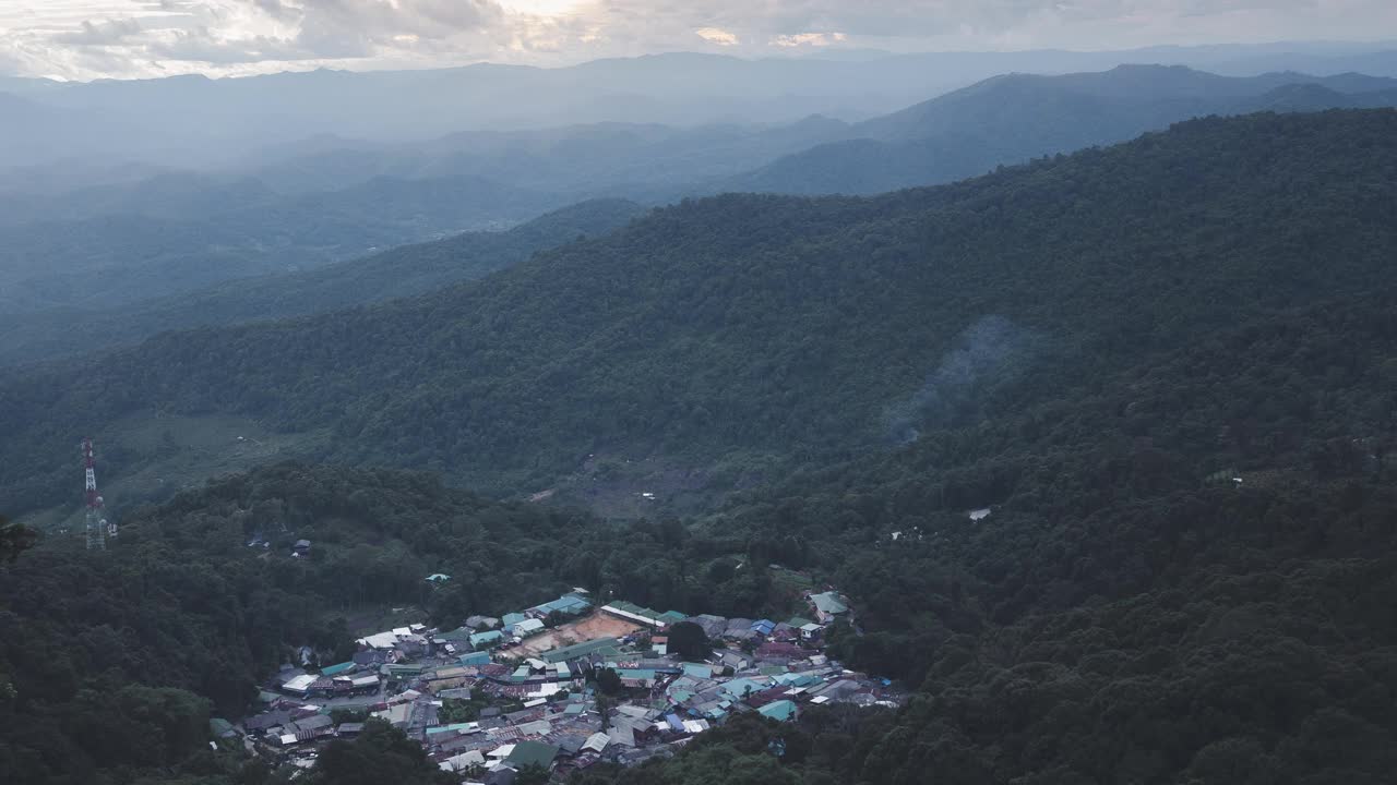 随着时间推移，雾和烟在山谷中的一个小村庄上空飘过。视频素材