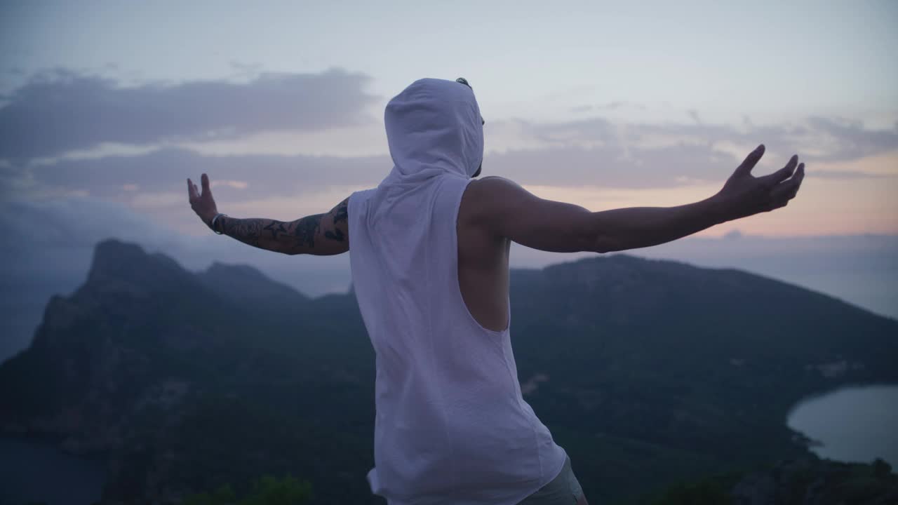 站在世界之巅的男人。徒步旅行后站在山顶上看风景视频素材