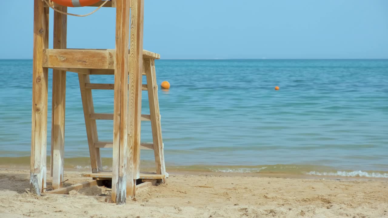 夏季，海边沙滩上空荡荡的木制救生员站视频素材