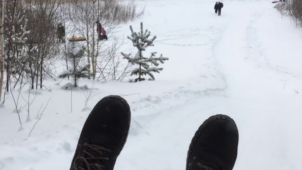 冬天在被雪覆盖的木质滑梯上坐雪橇视频素材